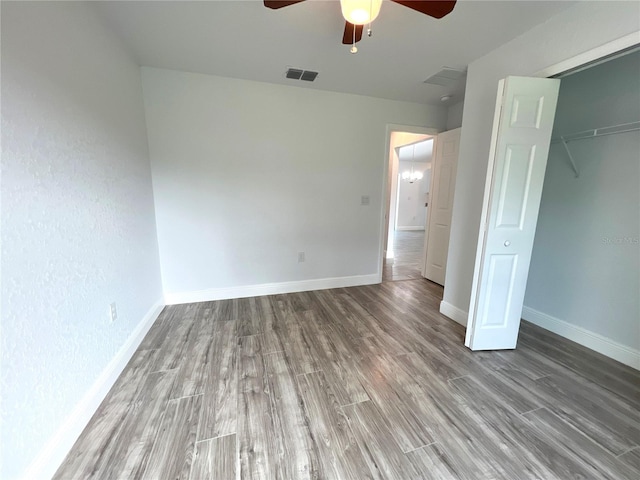 unfurnished bedroom featuring hardwood / wood-style flooring, a closet, and ceiling fan