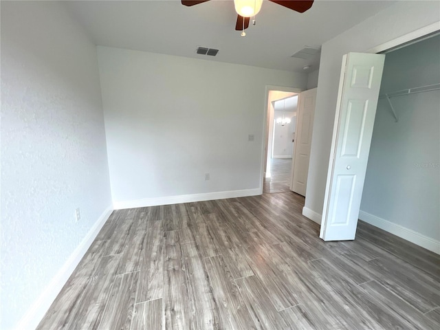 unfurnished bedroom with wood finished floors, baseboards, a ceiling fan, and a closet
