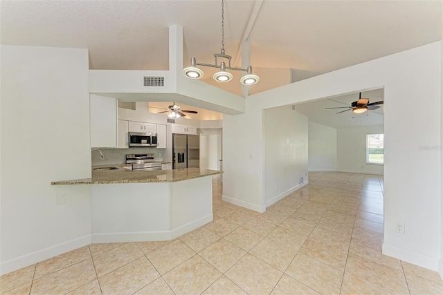 kitchen featuring stainless steel appliances, white cabinetry, light stone counters, kitchen peninsula, and decorative light fixtures