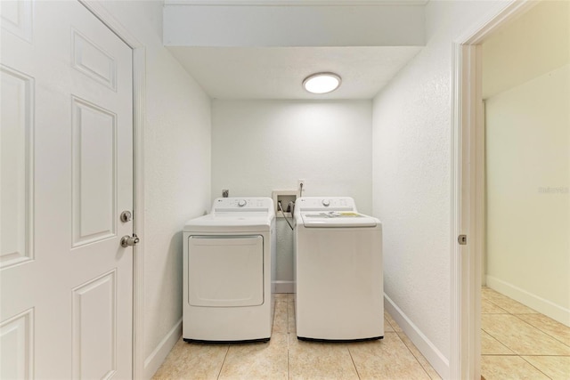 laundry area with light tile patterned flooring and independent washer and dryer