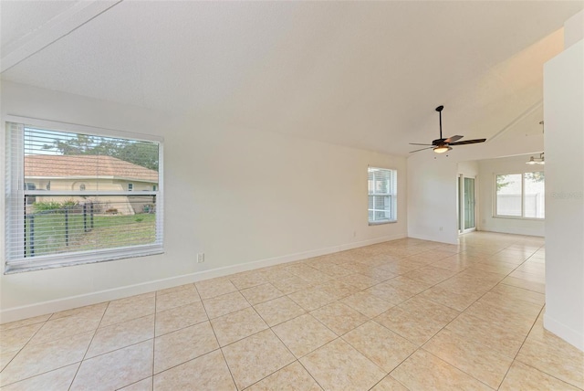 tiled empty room featuring ceiling fan, plenty of natural light, and lofted ceiling