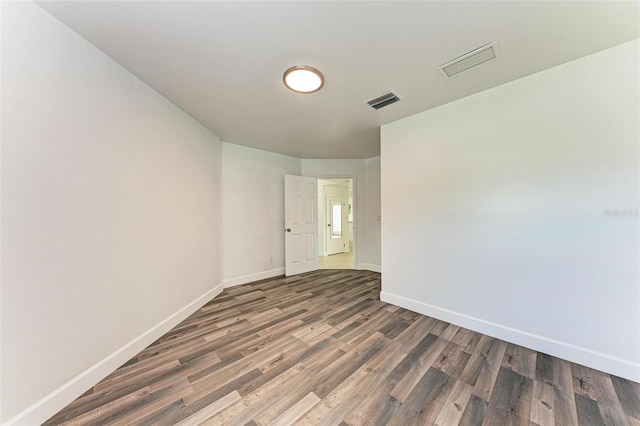 unfurnished room with dark wood-type flooring