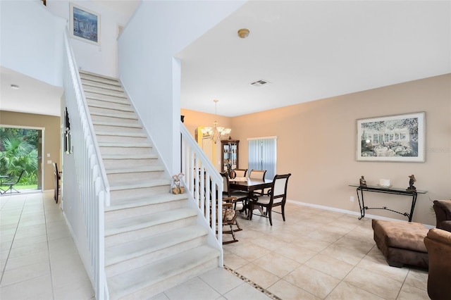 staircase featuring a chandelier and tile patterned flooring