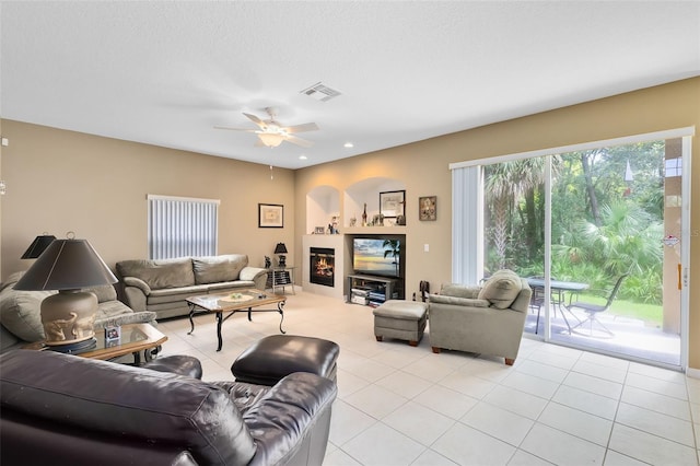 tiled living room featuring a textured ceiling and ceiling fan