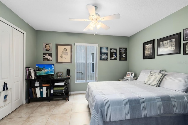 bedroom featuring light tile patterned floors, ceiling fan, and a closet