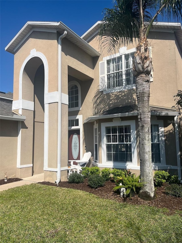 view of front of home with stucco siding and a front yard