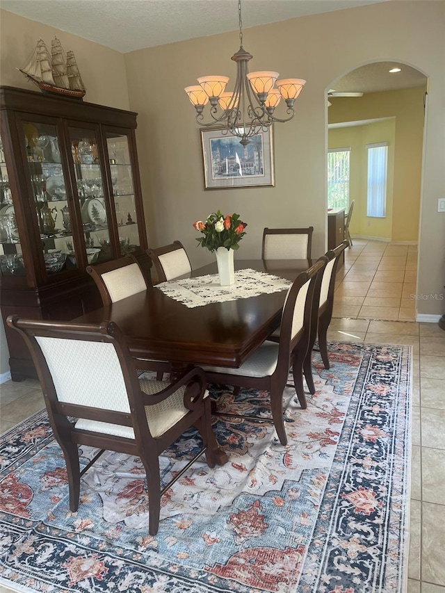 tiled dining space with a notable chandelier and a textured ceiling