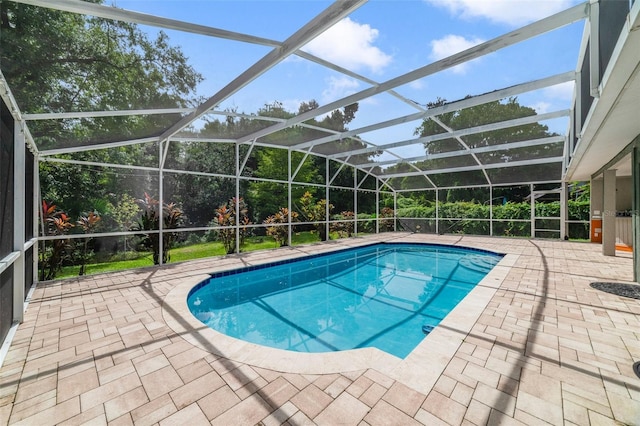 view of pool with glass enclosure and a patio area