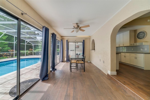 view of swimming pool featuring arched walkways and a ceiling fan