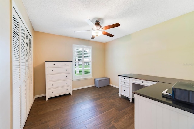 office featuring a ceiling fan, dark wood-style flooring, and a textured ceiling