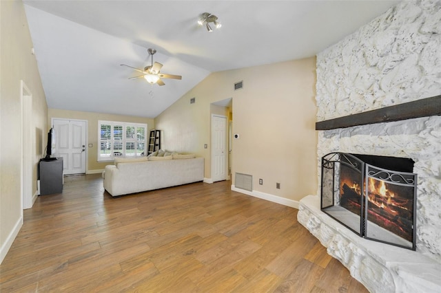 668 Coral Way, Winter Springs, FL 32708 - living area featuring a stone fireplace, a ceiling fan, visible vents, lofted ceiling, and wood finished floors