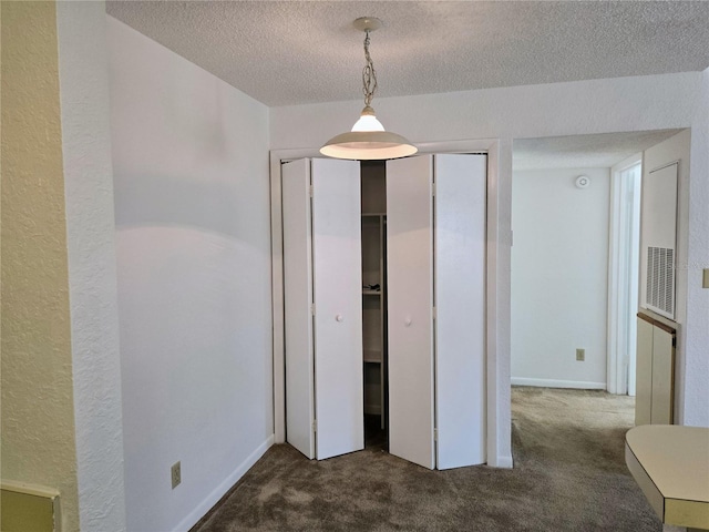 unfurnished bedroom with a textured ceiling and carpet