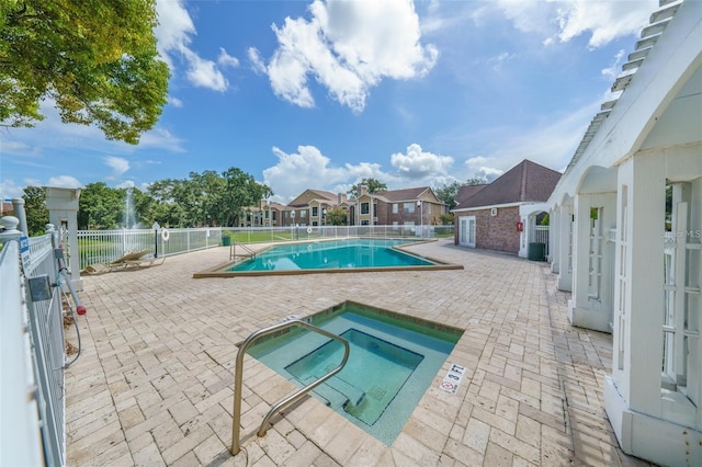 view of pool featuring a patio area and a hot tub