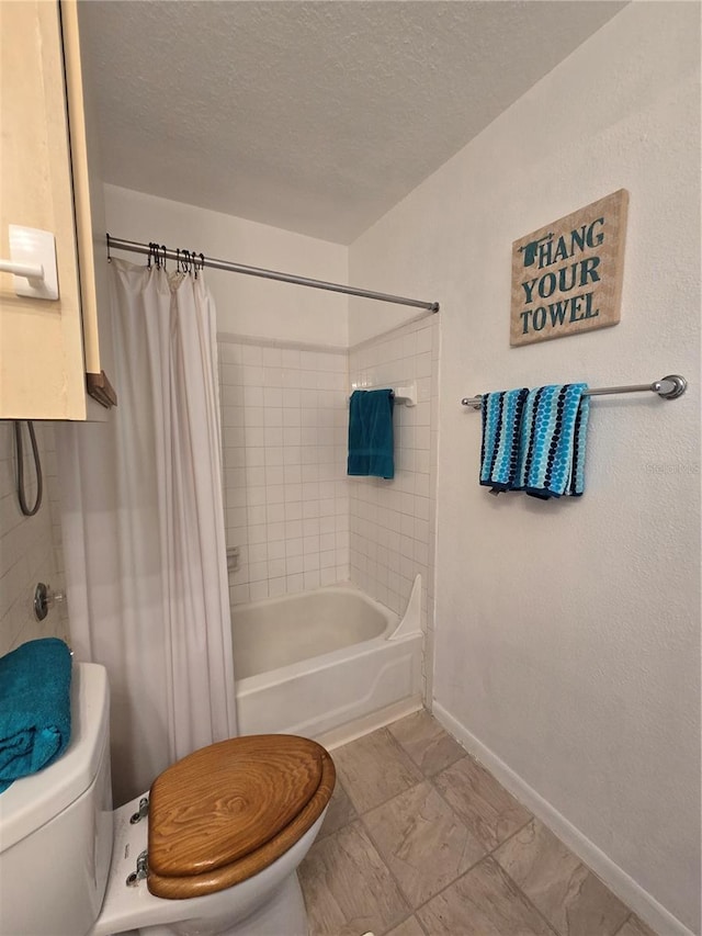 4401 Thornbriar Ln Unit 202, Orlando, FL 32822 - bathroom featuring toilet, shower / bath combo with shower curtain, a textured ceiling, and baseboards