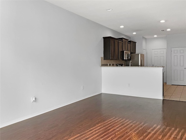 unfurnished living room featuring sink and hardwood / wood-style floors