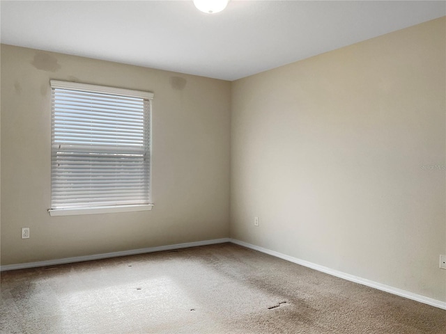 carpeted empty room with baseboards