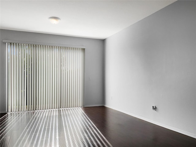 empty room featuring baseboards and wood finished floors