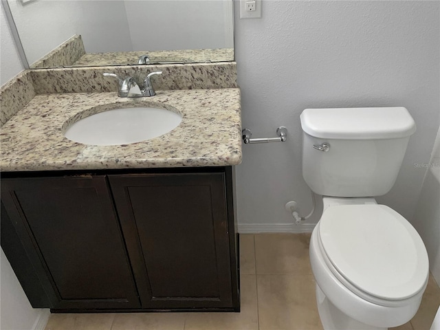 bathroom featuring tile patterned flooring, vanity, and toilet