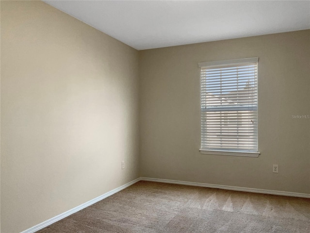 spare room featuring baseboards and carpet