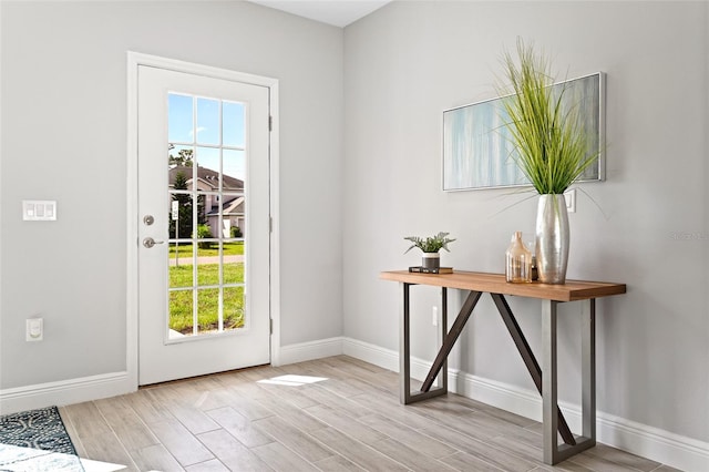 doorway to outside featuring a healthy amount of sunlight and light hardwood / wood-style flooring