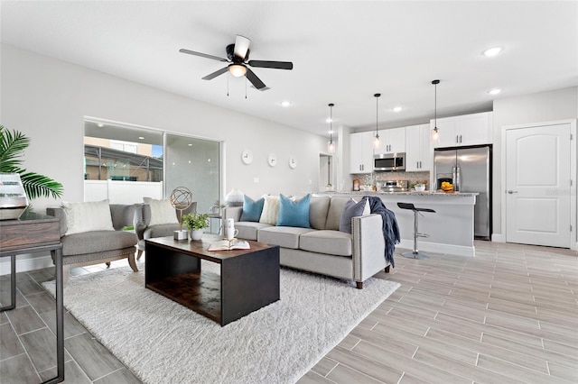 living room with light wood-type flooring and ceiling fan