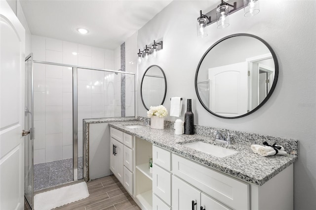 bathroom with vanity, wood-type flooring, and a shower with shower door