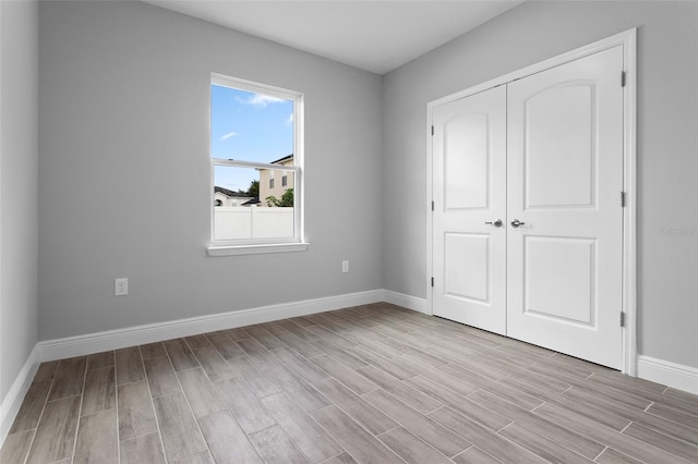 unfurnished bedroom with light hardwood / wood-style flooring and a closet