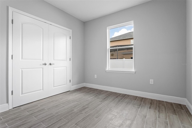 unfurnished bedroom with light hardwood / wood-style flooring and a closet