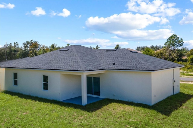 rear view of house featuring a lawn and a patio area