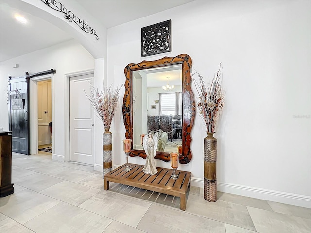 corridor with a barn door and a notable chandelier