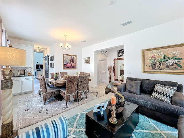 tiled living room featuring a chandelier