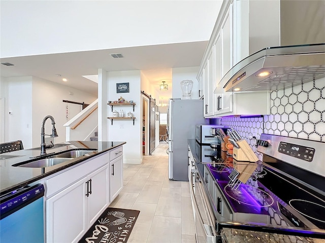 kitchen with stainless steel appliances, sink, wall chimney exhaust hood, and white cabinetry