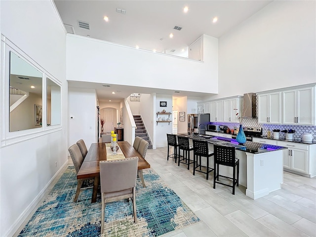 dining area featuring a high ceiling and light tile patterned flooring