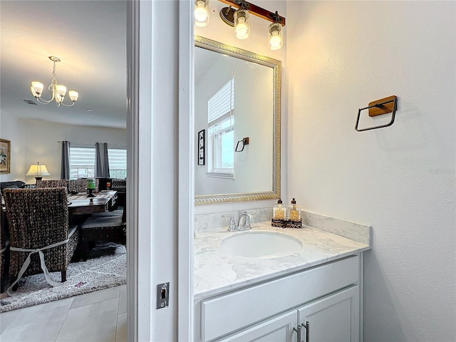 bathroom featuring vanity, an inviting chandelier, and tile patterned floors