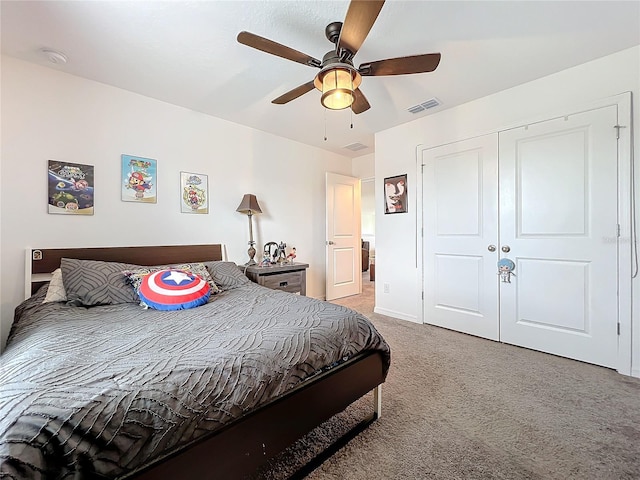 bedroom with a closet, ceiling fan, and light colored carpet