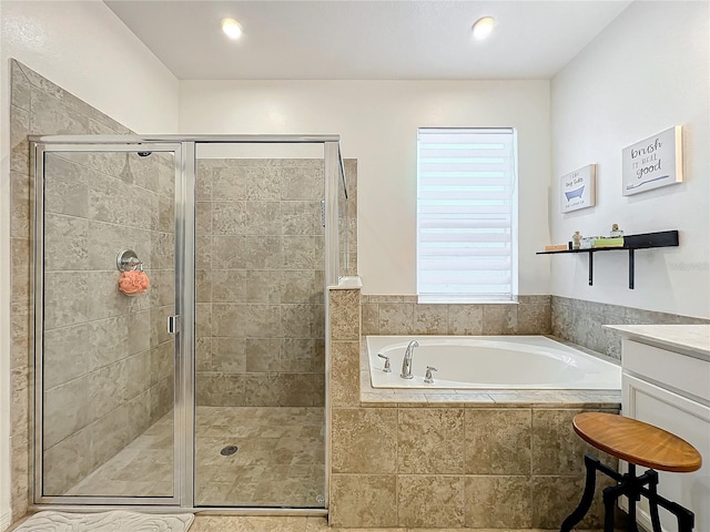 bathroom with vanity and shower with separate bathtub