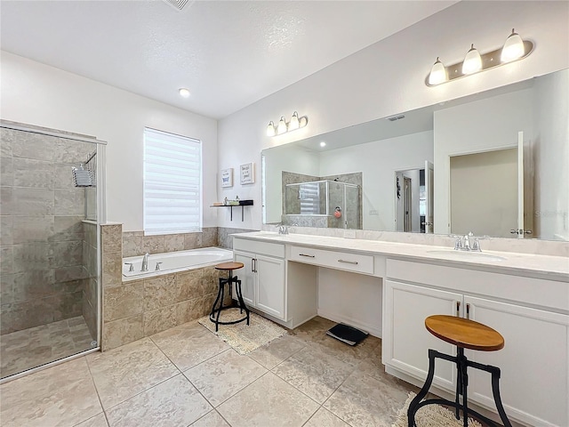 bathroom featuring tile patterned floors, shower with separate bathtub, a textured ceiling, and vanity