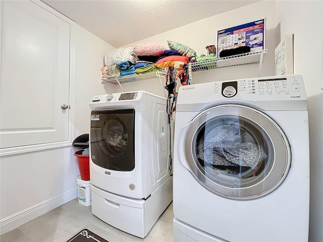 clothes washing area featuring washer and clothes dryer and a textured ceiling