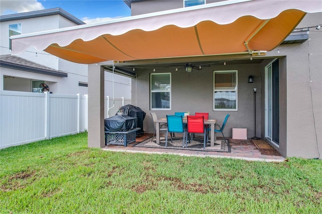 back of house featuring ceiling fan, a lawn, and a patio area