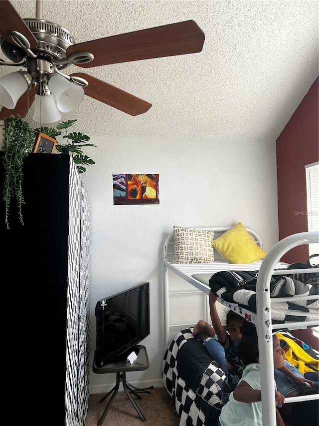 carpeted bedroom with a textured ceiling, ceiling fan, and vaulted ceiling