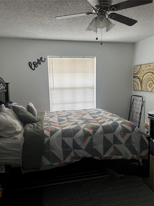 carpeted bedroom with a textured ceiling and ceiling fan