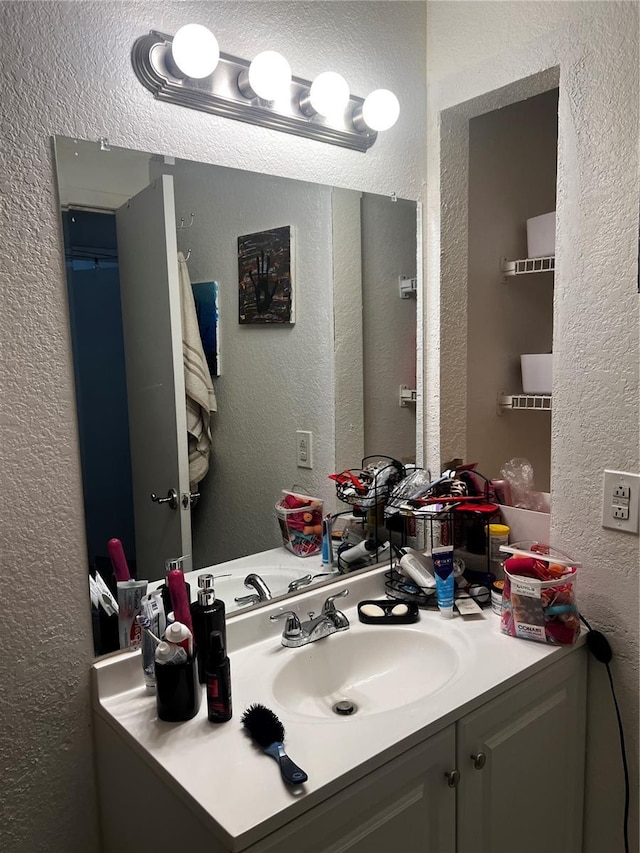 bathroom featuring vanity and a textured wall