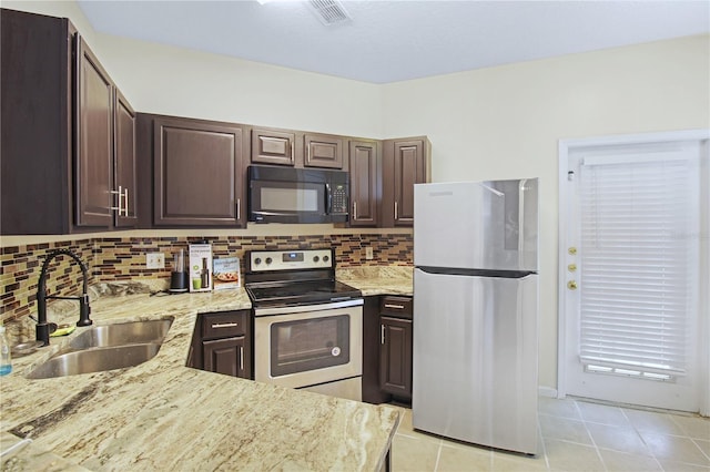 kitchen featuring light stone countertops, stainless steel appliances, dark brown cabinets, and sink