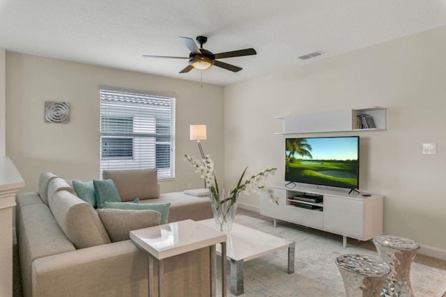 carpeted living room with a textured ceiling and ceiling fan