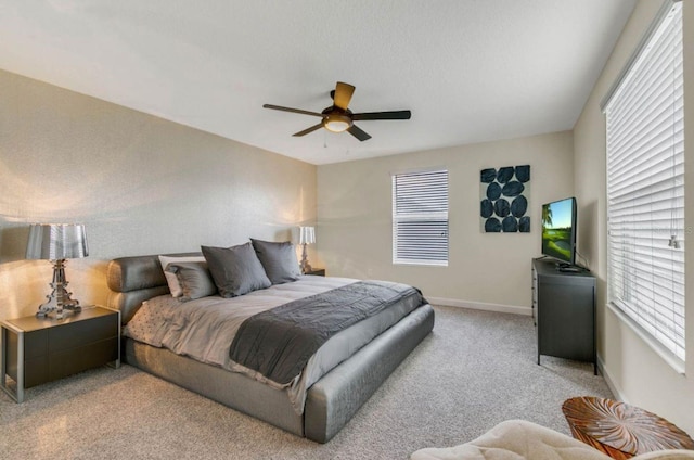 carpeted bedroom with multiple windows and ceiling fan