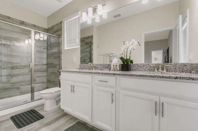 bathroom featuring vanity, toilet, hardwood / wood-style flooring, and a shower with shower door