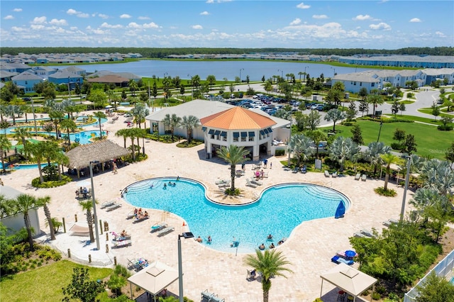 view of swimming pool featuring a water view, a gazebo, and a patio area