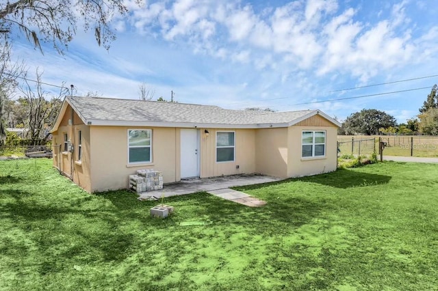 5351 E Johnson Ave, Haines City, FL 33844 - rear view of house featuring fence, stucco siding, a yard, and roof with shingles