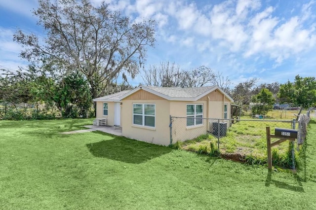 view of side of home featuring central AC unit and a yard