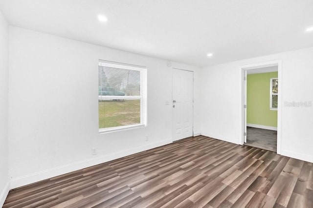 empty room with dark hardwood / wood-style flooring